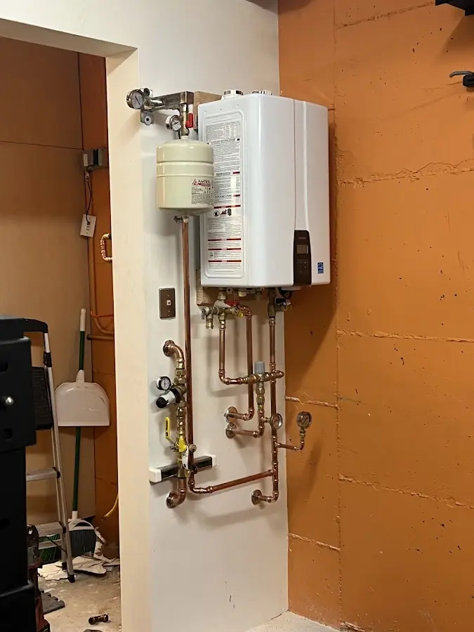 Plumbing technician inspecting water heater connections in Brewton